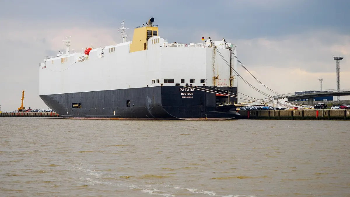 A car carrier ship moored with its vehicle ramp down at the port of Emden, Germany