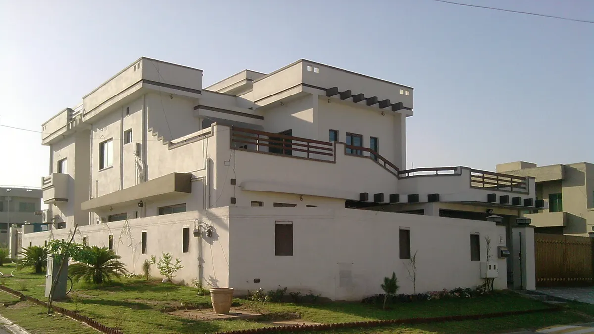 A corner house in Rawalpindi set back from the road behind a front lawn