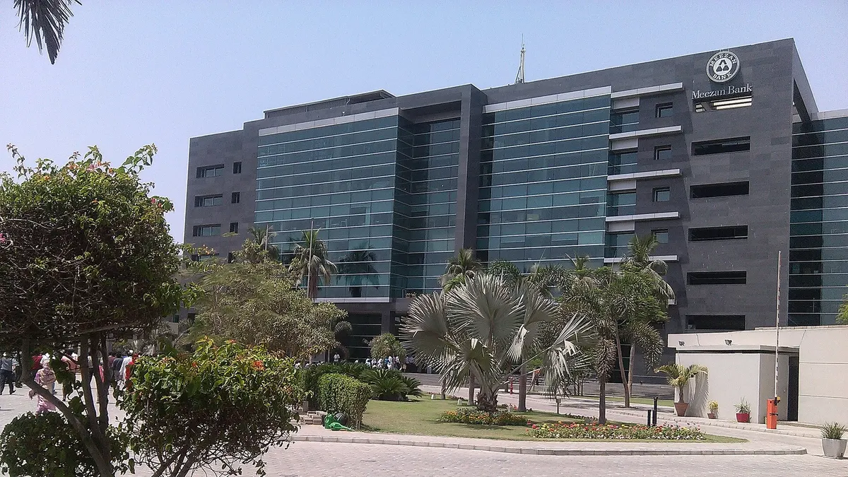 Meezan Bank's head office building in Karachi, behind a landscaped garden