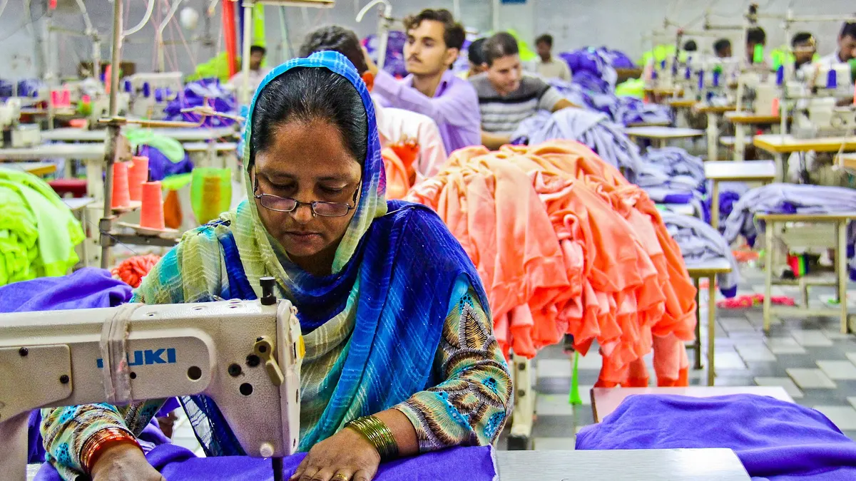 Workers at sewing machines in a garment factory in Pakistan