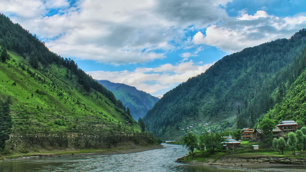 The Neelum River winding between forested mountains in Neelum Valley, Azad Kashmir