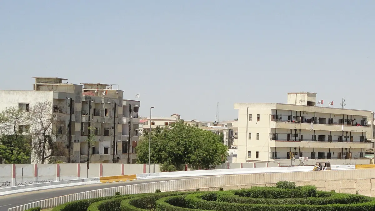 Four-storey blocks of flats beside a road in Sohrab Goth, Karachi
