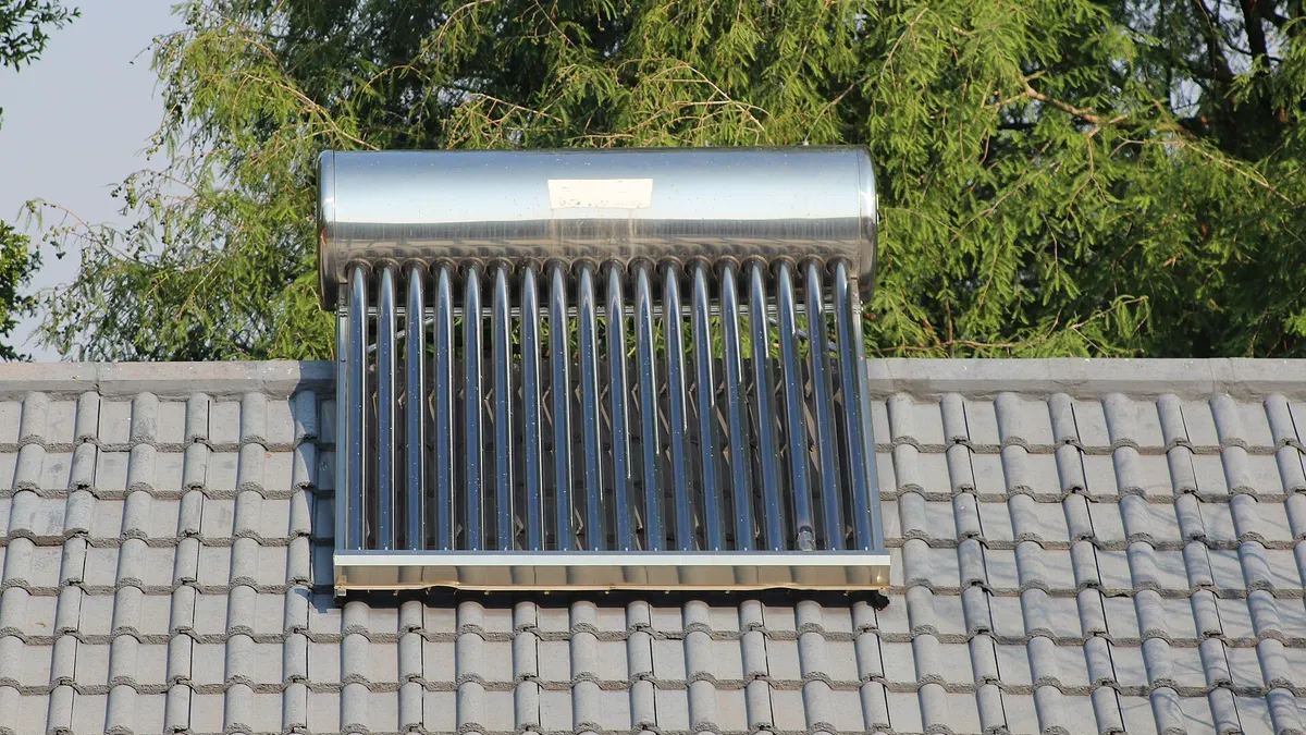 An evacuated-tube solar water heater on a tiled house roof in South Africa