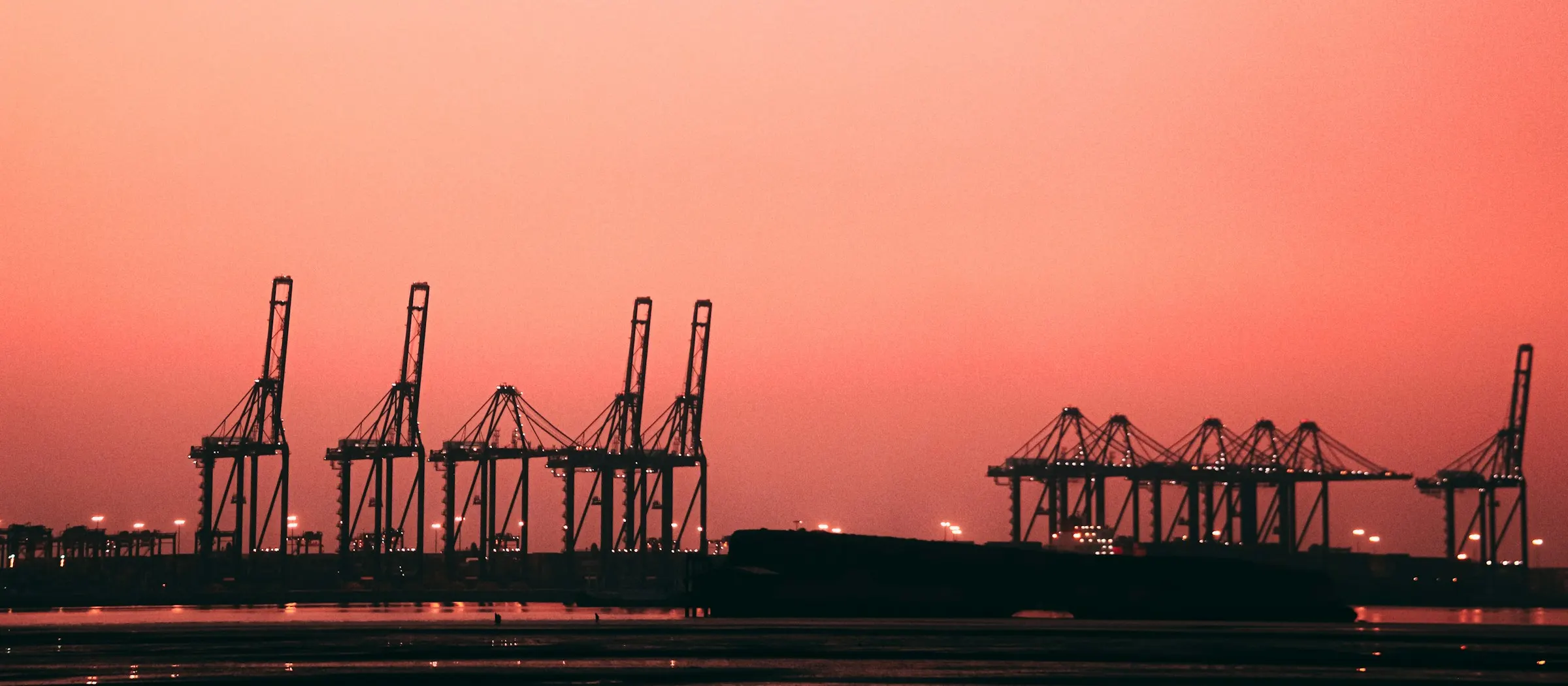 Container cranes at a port at sunset