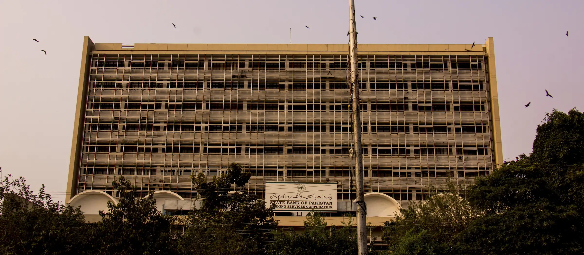 State Bank of Pakistan Banking Services Corporation building behind a row of trees